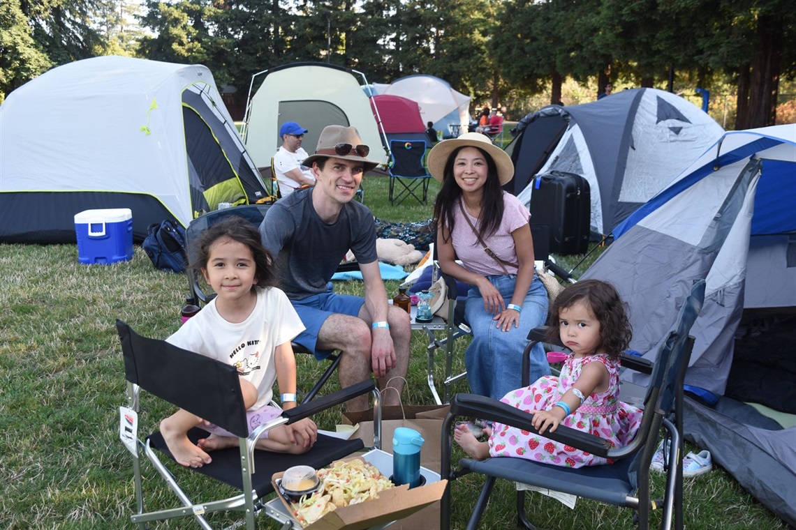 Happy family in front of tents at park