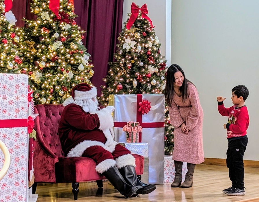 Child and adult speaking with Santa