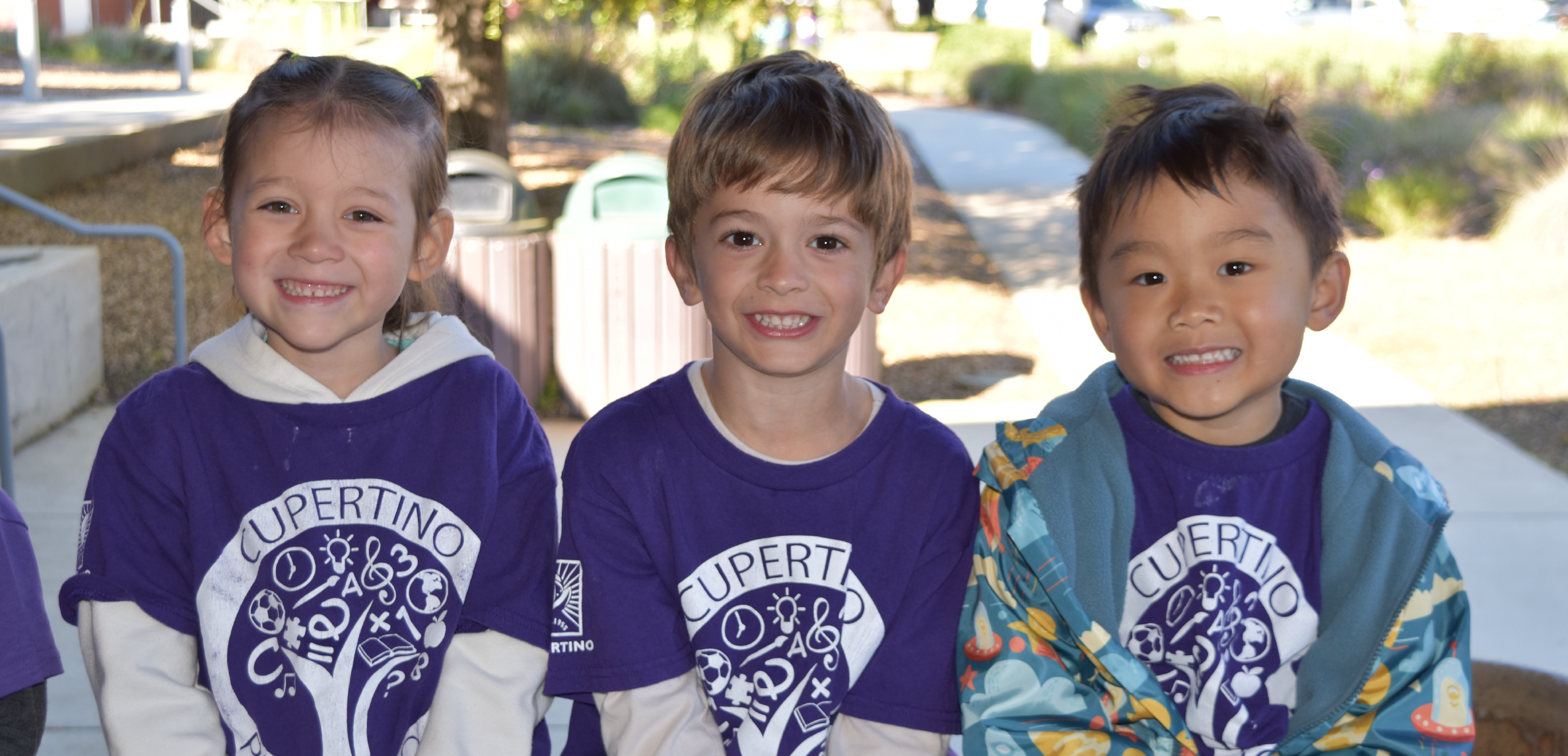 Three preschool kids on a bench.