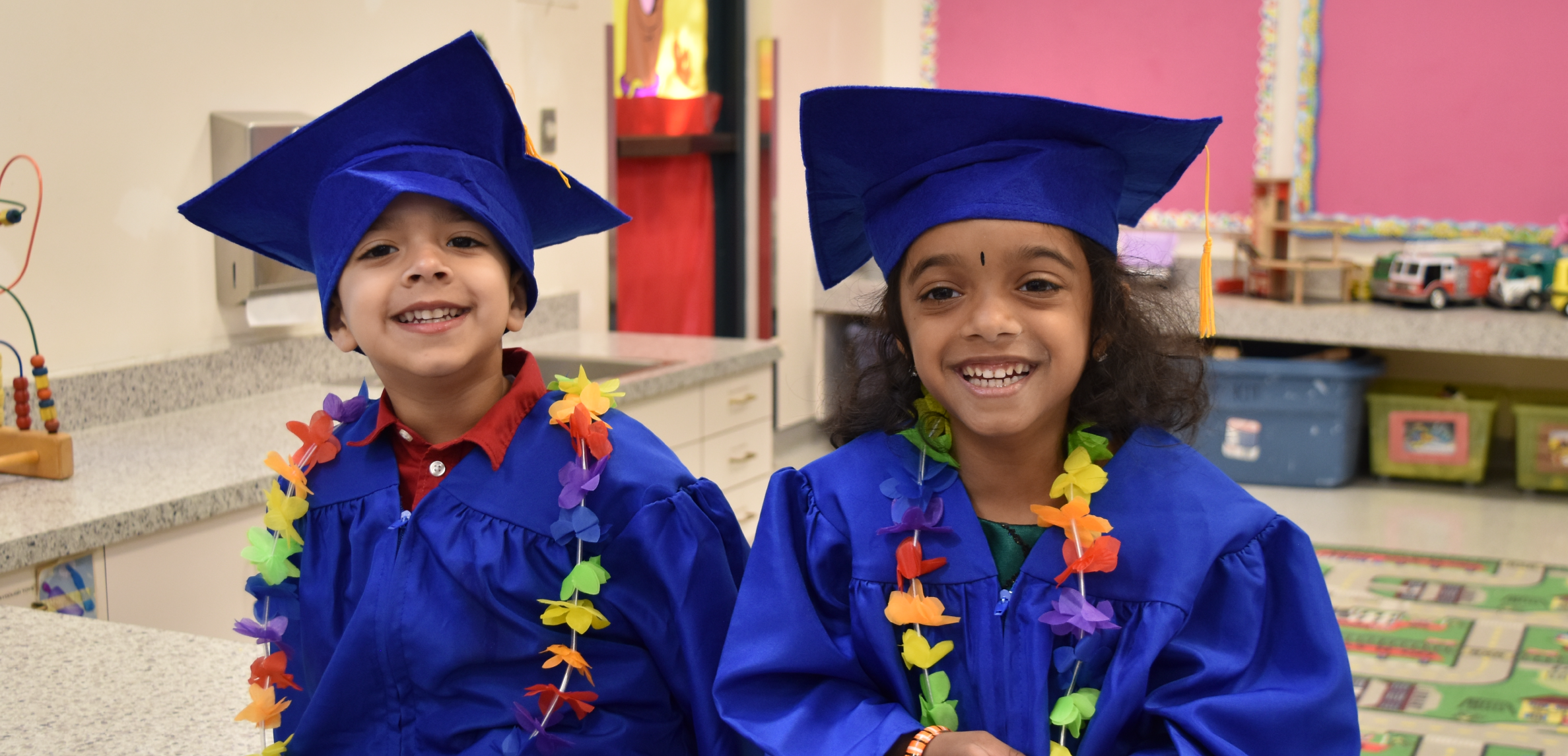 Preschool kids in graduation cap and gown.